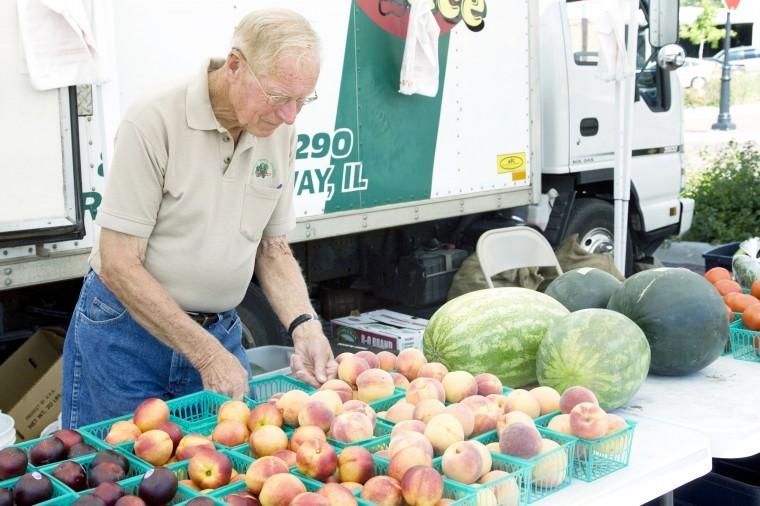 Milt Westlake, owner of, Norway Farms Produce, rearranges his produce at the DeKalb Farmers Market  Thursday afternoon. Norway Farms has been selling their produce for 15 years at this farmers market. 