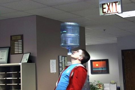 Colin Sullivan, junior education major, shows off his routine by balancing a water jug on his chin in the Northern Star newsroom.