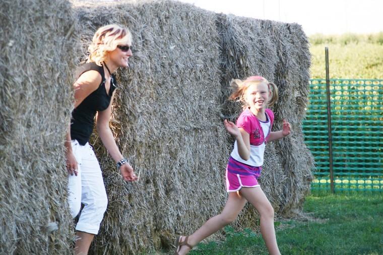 Angelina Terry, 7, of Paw Paw, exits the hay bale maze with her mother, Dianna Terry in hot persuit, Tuesday afternoon at the Honey Hill Orchard in Waterman, Ill..