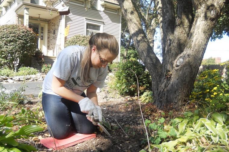 Joslyn Martarano, freshman undeclared major, plants tulips outside of the Pay-It-Forward House during Selfless Saturdays hosted by the Womens Resource Center.