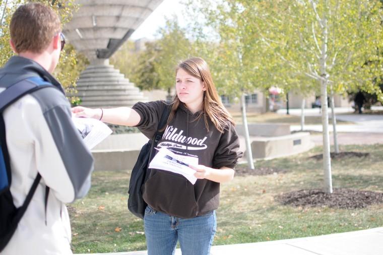 Junior sociology major Emma Booras hands out fliers Tuesday at the MLK Commons with information about missing NIU student Antinette Keller. 