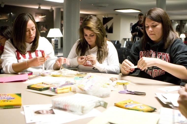 Huskies United members (from left) Liz Yee, Danielle Bowen and Melissa Idstein work on making ribbons to raise awareness of missing student Antinette Keller Thursday night in the Holmes Student Center. Huskies United members, students, and others made cards and fliers as well as ribbons to help the cause.