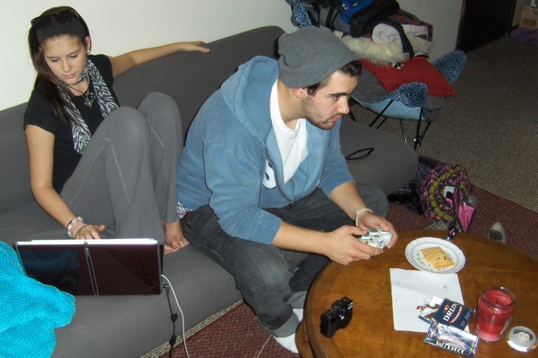 Casey Lange, senior art history major, plays video games in his apartment on West Hillcrest Drive as Megan Millon, junior physical therapy major, browses on a laptop Wednesday afternoon.