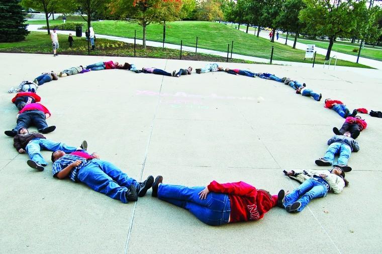 Supporters of the LGBT Resource Center form a heart outside of the Holmes Student Center on Sunday as a part of the annual You Are Loved campaign. 