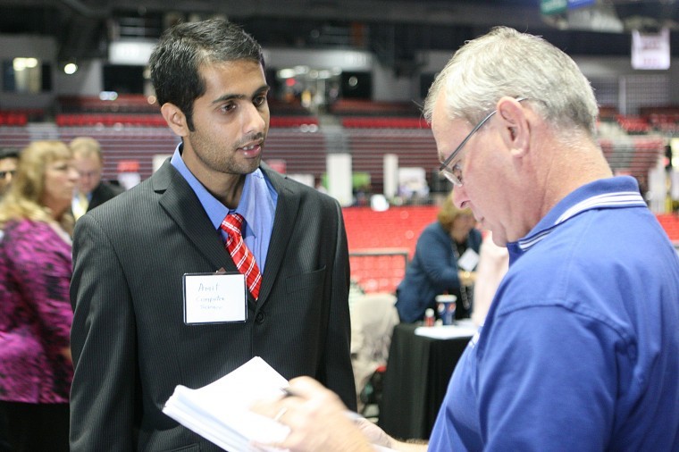 Amit Aher, computer science graduate student, speaks with Bill Jahncke of Allstate Insurance during the Career Services Fall Job Fair on Wednesday afternoon in the NIU Convocation Center. Allstate Insurance was one of over 125 employers in attendance at the annual fair.
