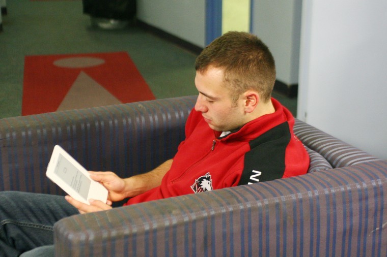 Joseph Lassin, freshman accountancy major, reads a book using an Amazon Kindle in Lincoln Hall. Local libraries, including the DeKalb Public Library, have seen increasing interest in e-books from patrons. 