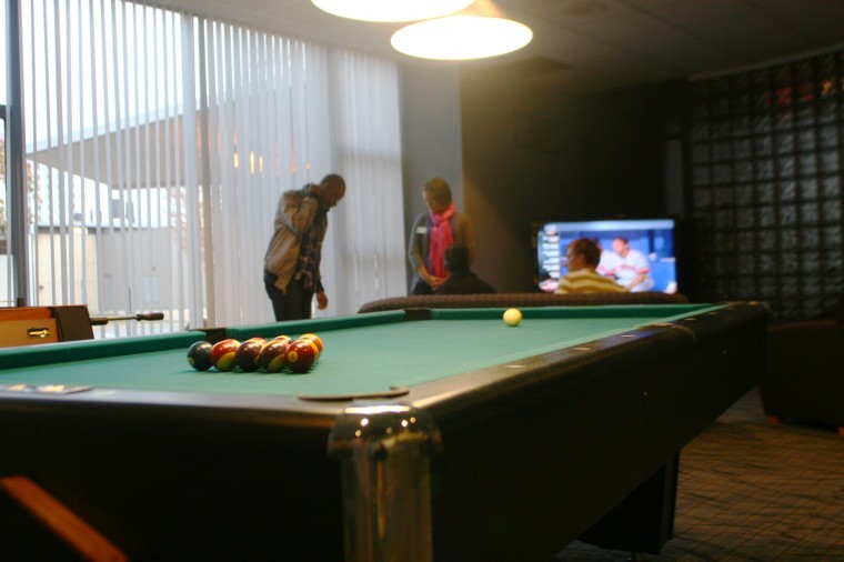 Students gather at the grand opening of the Lincoln game room Thursday night. The room features a pool table, foosball table, large TV and couches.
