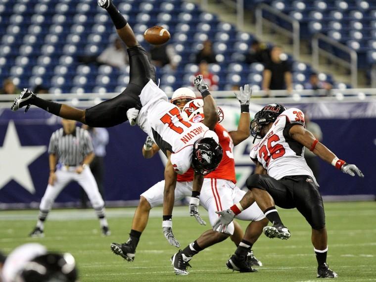 Rashawn Melvin (11) dives for a tipped pass by Tyrone Clark (36). The tipped pass was caught by Miami (OH) to complete a 4th and 20 Friday night during the MAC Championship. 