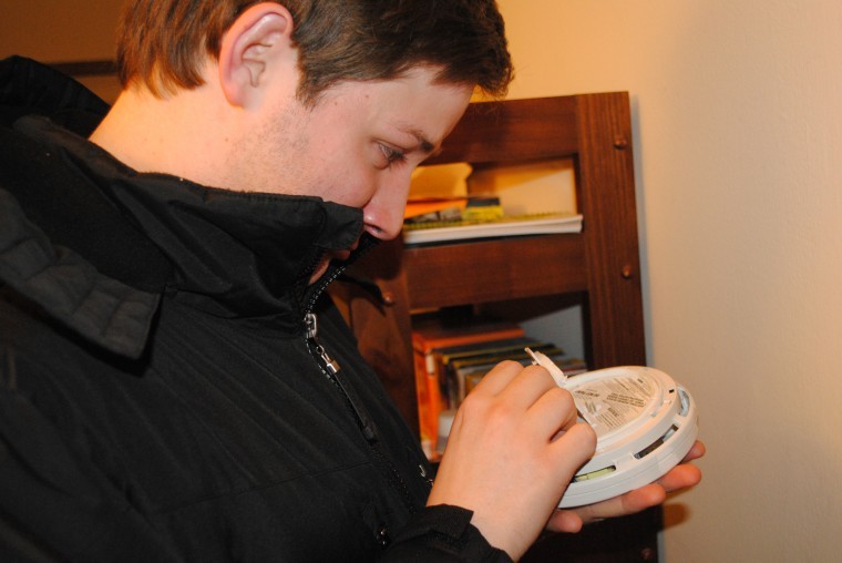 David Zucker, senior philosophy major, changes the batteries in the smoke detector at this apartment, a common practice that residents should do frequently according to the DeKalb Fire Department. 