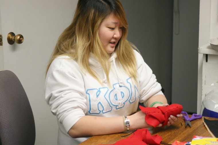 Darae Song, senior FCNS major and Kappa Phi Lambda member, makes a heart pillow for the elderly during a Valentines Day event at the Asian American Center.
