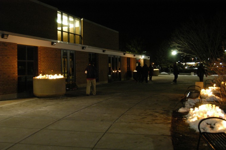 NIU students leave flowers and candles at Cole Hall after the 2009 candlelight vigil honoring the victims of the Feb. 14 shootings.                                 