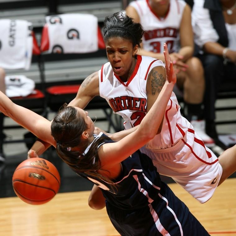 Danielle Pulliam charges through an Akron defender Saturday night, drawing a block foul and earning two free throws. NIU lost 72-43. 