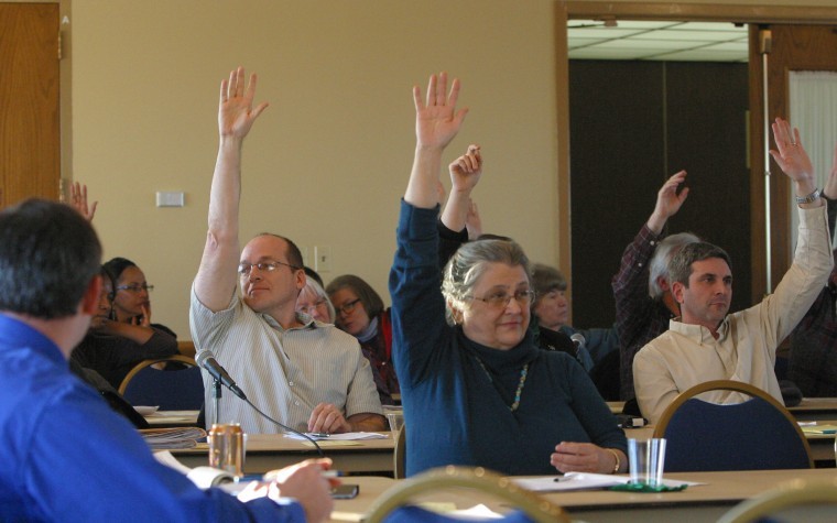 Patricia Henry (middle), foreign language and literature professor, raises her hand in support of the Plus-Minus Bill proposed to the Faculty Senate Wednesday in the Sky Room of the Holmes Student Center.  