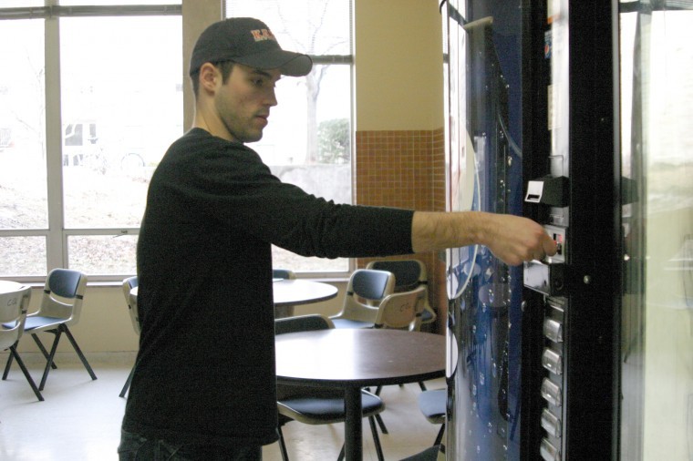 Third year law student Chad Lewis puts money in a Pepsi vending machine at Swen Parson Hall. A portion of the money earned at vending machines go contribute to scholarships. 