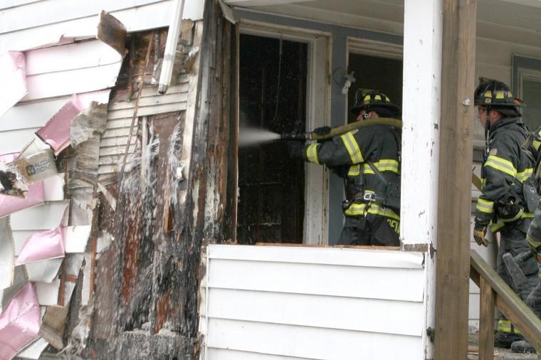 Firefighters battle an electrical fire at 414 Prospect St. in DeKalb Tuesday morning. 