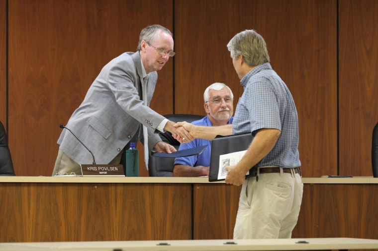 DeKalb Mayor Kris Polvsen shakes hands with DeKalb resident while 5th Ward Alderman Ron Naylor looks on in 2011.
