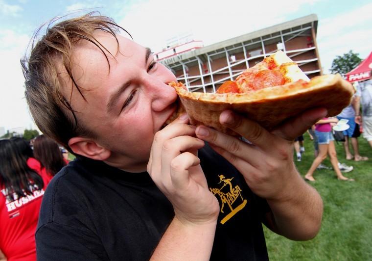 Will Rhode, freshman computer and design tech major, eats a
slice of pizza at the Huskie Bash at Huskie Stadium on Thursday
afternoon.
