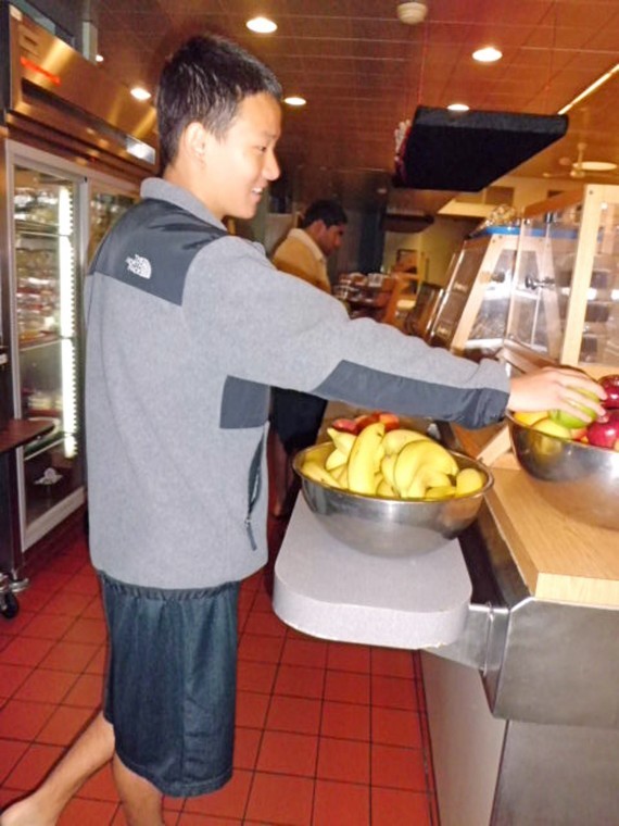 Freshman English major Hantac Chang grabs a piece of fruit while
going through the line in Dog Pound Deli in Douglas Hall.
