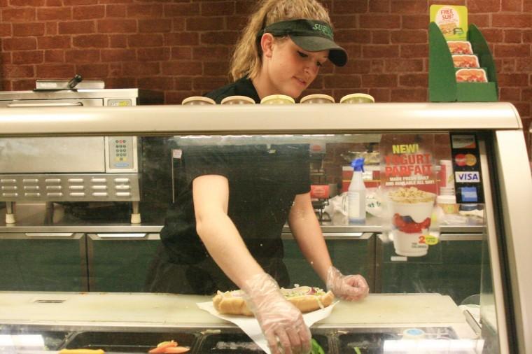 Senior psychology major Natalie Herzog prepares a footlong sub
at the Subway located in the Holmes Student Center Monday
evening.
