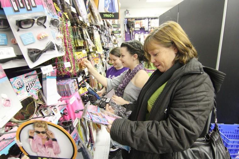 Sycamore residents Amy Munro (right), 42, and daughters Whitney
(center), 16, and Kailey (left),14, browse for Halloween costumes
at Party City, 2350 Sycamore Road, Wednesday night.
