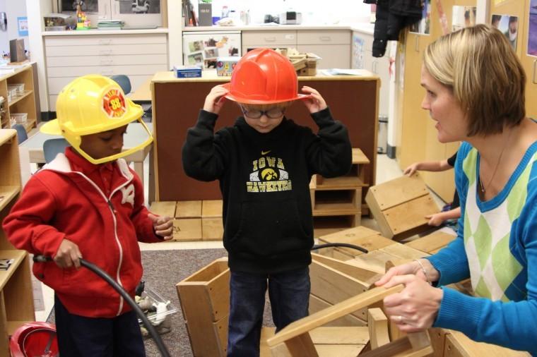 Child Development Supervisor Diane Mathison helps Cameron, 3,
and Evan, 4, build a firetruck at the Campus Childcare Center on
Monday evening.
