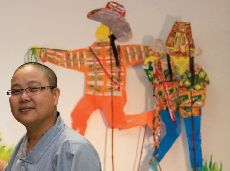 Siew Lian Lim, sculpture graduate student and Buddhist nun,
stands in front of her shadow puppets, which she fashioned from
refuse material such as aluminum cans, food wrappers and
Styrofoam.
