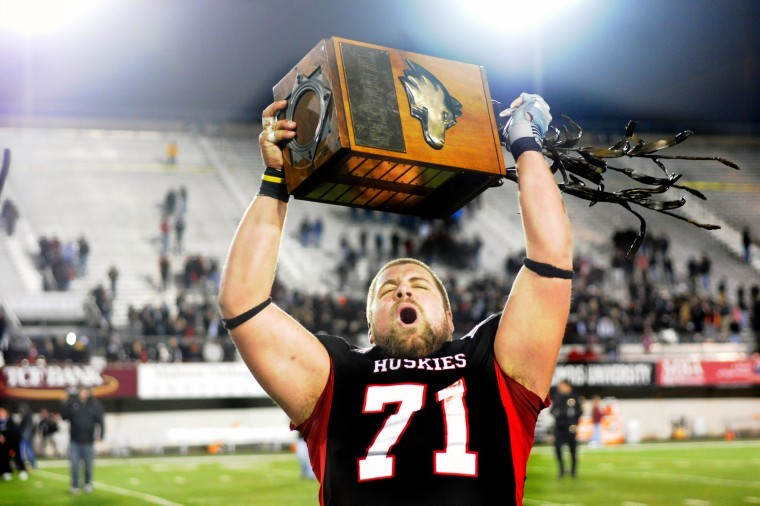 Huskie center Scott Wedige holds up the Bronze Stalk Trophy,
which has been awarded to the winner of the NIU-Ball State game
since 2008. NIU defeated the Cardinals for the third straight
season, by a score of 41-38.

