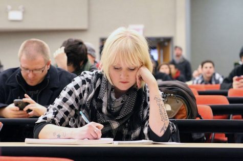 NIU student Alyssa Witherby, junior communications major, takes
notes prior to her Communications 356 class in Cole Hall.