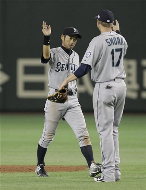 Seattle Mariners rightfielder Ichiro Suzuki, left, celebrates with first baseman Justin Smoak after beating the Oakland Athletics 3-1 in their American League season opening MLB baseball game at Tokyo Dome in Tokyo, Wednesday, March 28, 2012. (AP Photo/Shizuo Kambayashi)

