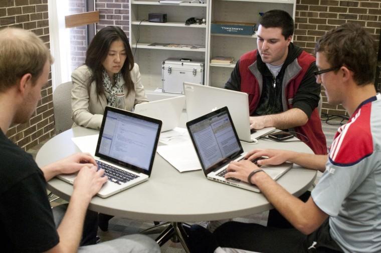 Greg Remiasz, senior computer science major, doctoral student Raye Chiang, Philip Pellicore, sophomore time arts major and Eric Russell, assistant coach of the team work on a literacy game for children in the Digital Convergence Lab Wednesday afternoon.
