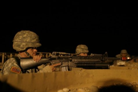 MSII Cadet Andrew Hansen, sophomore business administration major, secures the base during an exercise demonstrating a late-night attack during ROTC training at the Marseilles Training Center Friday night.