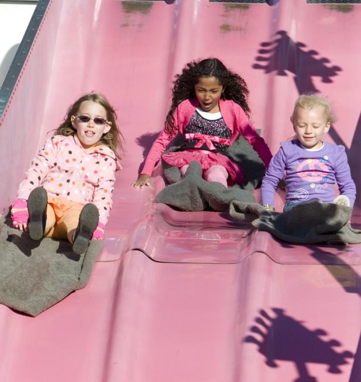 Olivia Thonsend (left)Jennifer Tsaras (center) Jenna Luetkebuenger (right) slides down a giant slide during September Fest at St. Mary’s School in DeKalb.
