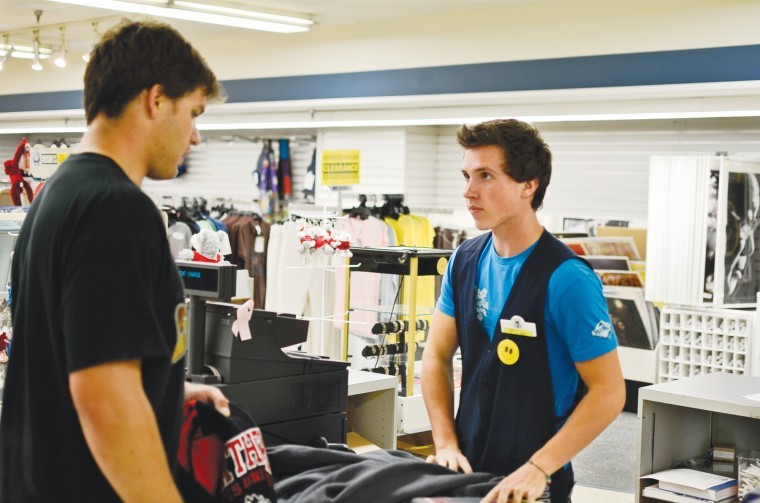 Junior illustration major Tim Schad bags items for junior kinesiology major Chris Golab in the student bookstore in the Holmes Student Center.
