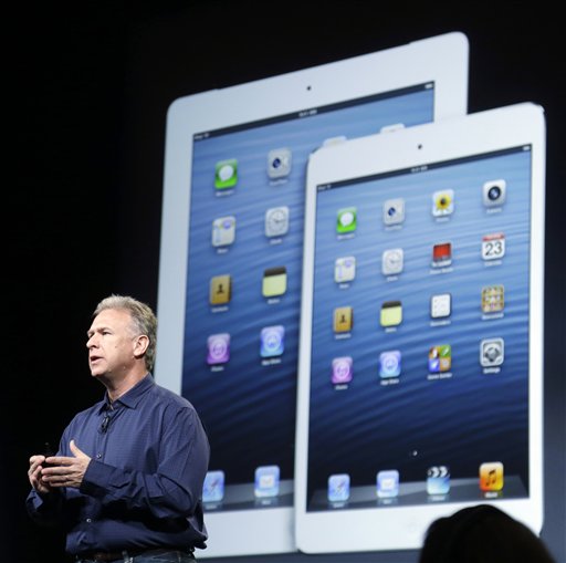 Phil Schiller, Apples senior vice president of worldwide product marketing, speaks in front of an image of the 4th generation iPad, at left, and the iPad mini in San Jose, Calif., Tuesday, Oct. 23, 2012. The iPad has a screen thats about two-thirds the size of the full-size model, and Apple says it will cost $329 and up.
