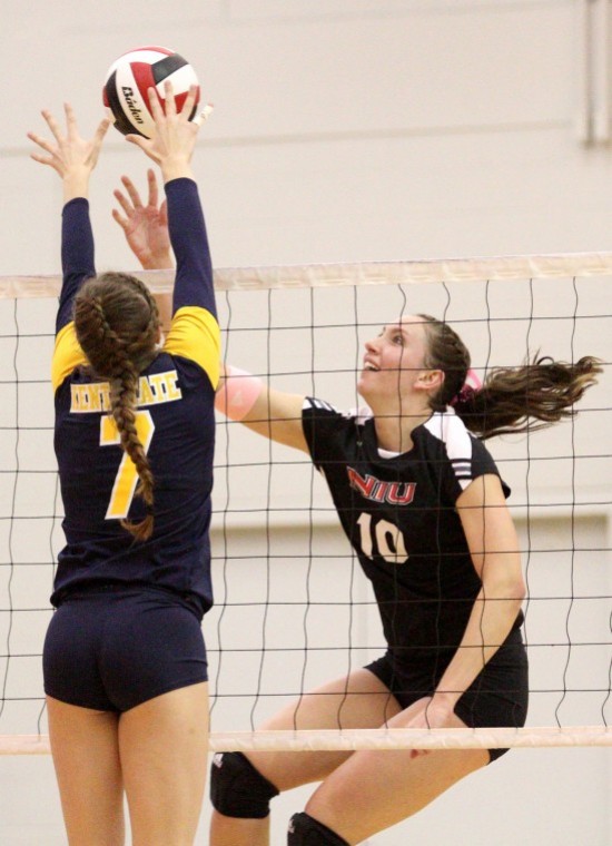 NIUs Mary Kurisch (10) goes to tip the ball over Kent States Maigan Larsen (7) as she blocks in the game Friday night.
