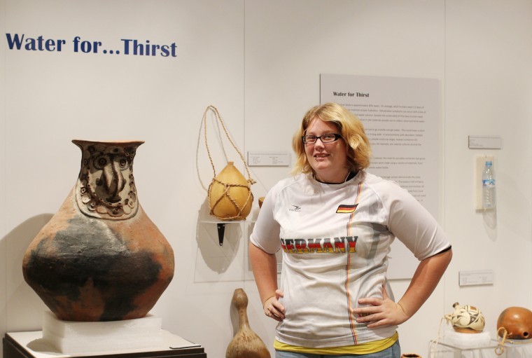 Anthropology Museum Docent, Paige Drauden, senior anthropology major, poses in front of a section of the Water for Life Exhibit in NIUs Anthropology Museum located in Cole Hall Friday afternoon. The exhibit explores the multiple ways societies have utilized water throughout history.
