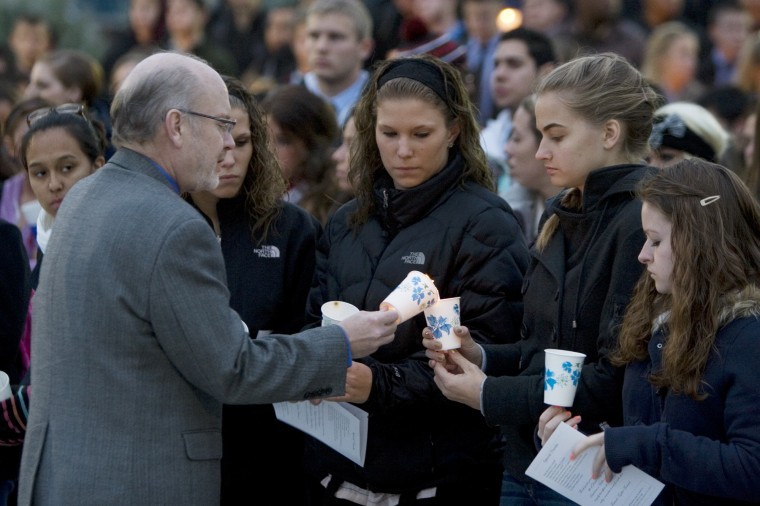 Reverend+Tom+Acton+David+Bogenbergers+pastor+assists+students+in+lighting+candles+for+candle+lighting+and+moment+of+silence+in+the+MLK+Commons.%0A