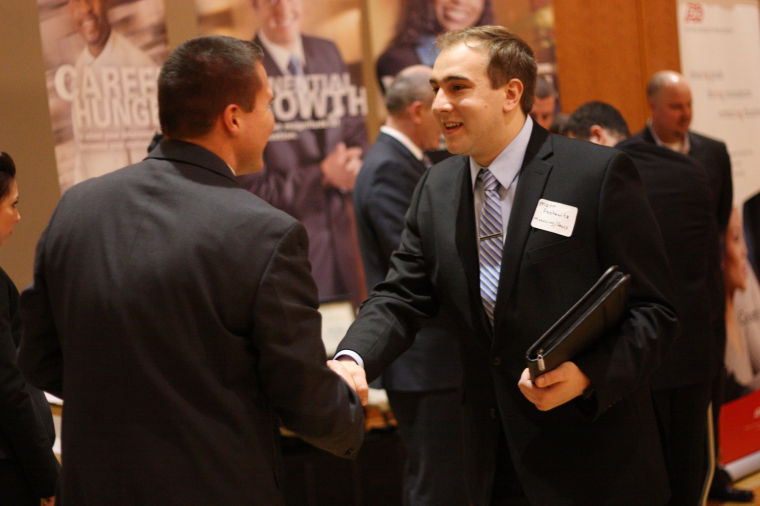 Marketing major, Matt Pashawitz shakes hands with an employer at the Marketing and Sales Talent Night at the Duke Ellington Ballroom in the Holmes Student Center on Monday evening.
