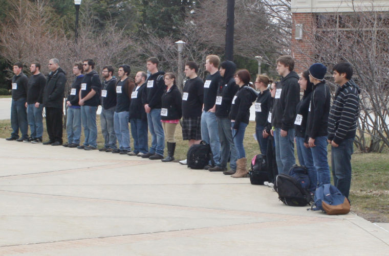 Members of Hillel (the Foundation for Jewish Campus Life) and Alpha Epsilon Pi stand silently Monday afternoon outside of Cole Hall in remembrance of victims of the Holocaust. The signs on their chests read: Never Forget.
