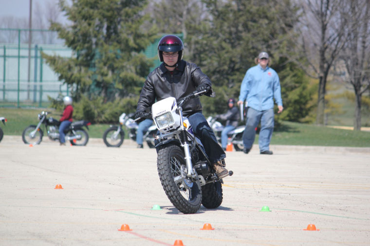 Man+maneuvers+motorcycle+through+cones+on+Sunday+afternoon+in+the+Anderson+Parking+Lot+for+a+motorcycle+training+class.%0A