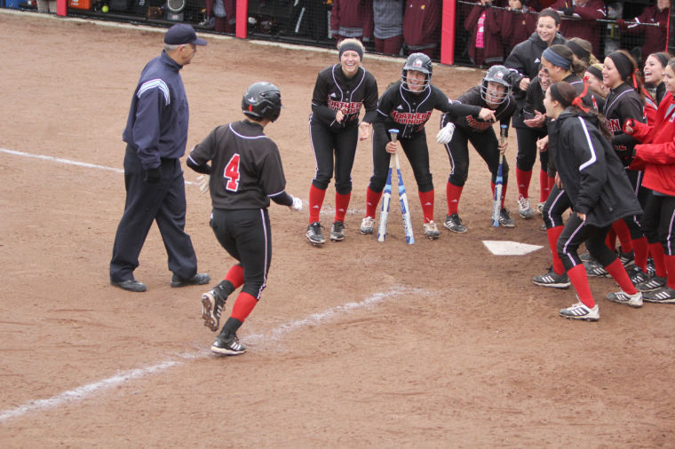 Junior Erika Oswald runs to home to celebrate with her teammates after she hit a home run on Friday in the game against Central Michigan University.
