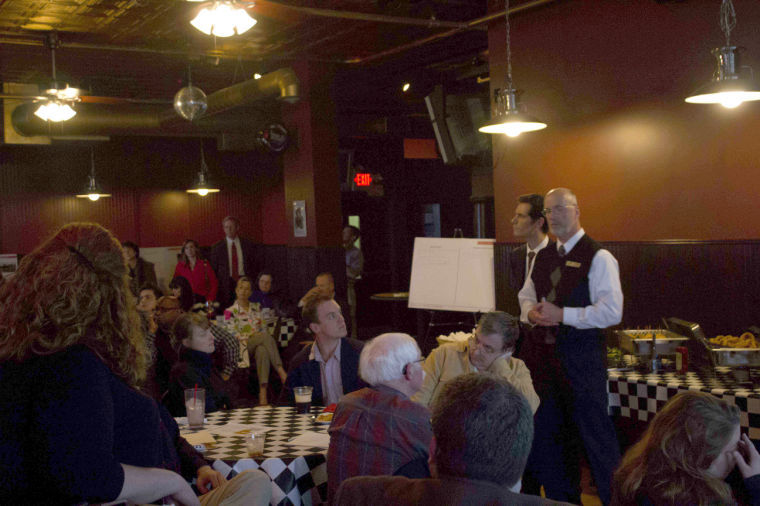 Architect and planner, David Schreiber (standing, on left) describes the current plans of Re:New DeKalb Inc., to revitalize DeKalb on Wednesday at an information meeting in OLearys Pub in downtown DeKalb.
