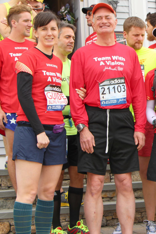 Josylynn Lee (left) and David Kuhn (right) pose for a photo before the start of the Boston Marathon.
