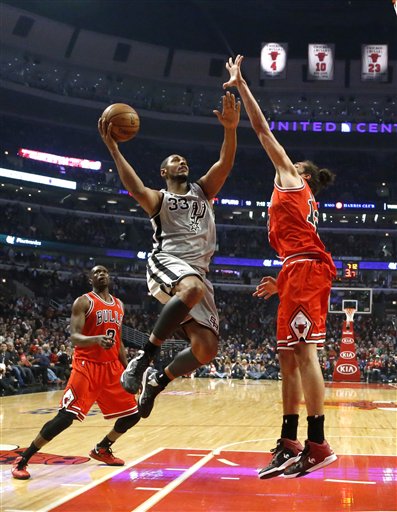 San Antonio Spurs center Boris Diaw (33) shoots over Chicago Bulls center Joakim Noah (13) as forward Luol Deng watches during the first half of an NBA basketball game, Monday, Feb. 11, 2013, in Chicago. (AP Photo/Charles Rex Arbogast)
