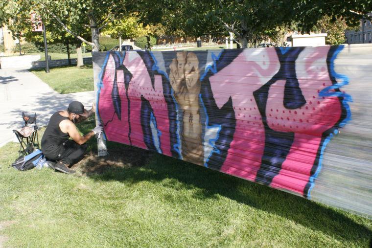 Mario “Kayo” Martinez, of Rockford, finishes up his tag work for the Unity Celebration sign on campus.