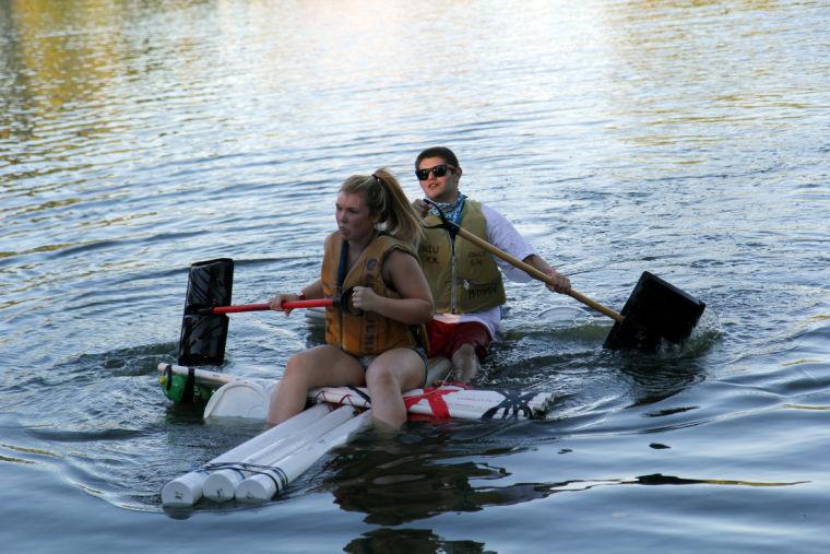 Sophomore communication major Marie Tasa and sophomore art major Nate Ardent paddle their boat, made of 90 percent recycled material, during the Recycle Boat Race on Tuesday in the East Lagoon.