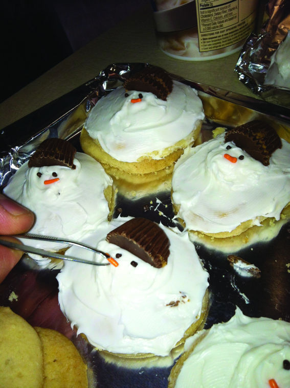 Place small peanut butter cups on top of the melting snowman cookie like a hat. 