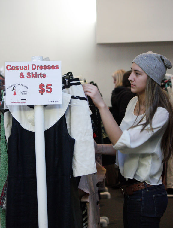 Lauren DeFries, student leader at Grace Place, looks through racks of clothing Friday afternoon during the Fabulous Fashionistas event at Grace Place, 401 Normal Rd. TAILS Humane Society hosted the Fabulous Fashionistas event where they sold designer clothing and shoes from upscale consignment shops for $3 to $5. Proceeds from the event are donated to caring for homeless animals.