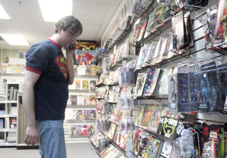Charles Fischer, Graham Crackers Comics owner, looks for comic for a customer April 21 at Graham Crackers Comics, 901 Lucinda Ave.