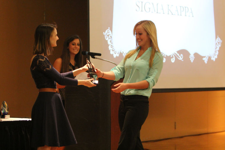 Helen Mellas, graduate assistant for Fraternity and Sorority Life within Student Involvement and Leadership Development and law student, gives an award to Lindy Luehowski, Sigma Kappa president and junior nursing major.